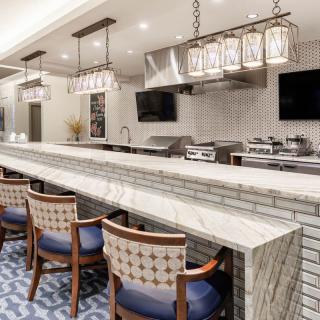 A modern kitchen bar area with a marble counter and stylish seating.