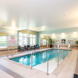 An inviting indoor swimming pool with surrounding seating in a well-lit recreational area.