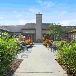 A well-maintained courtyard with a central pathway, surrounded by lush landscaping and outdoor seating.