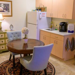A cozy kitchen and dining area with a round table, chairs, and appliances.