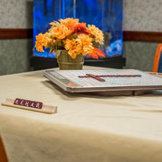 A cozy game night setup featuring a floral centerpiece and game tiles on a well-set table.