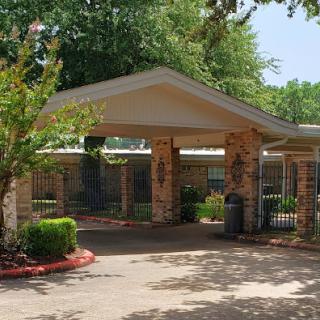The inviting entrance of a residential building surrounded by lush greenery.