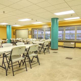 Empty classroom with tables and chairs arranged neatly.