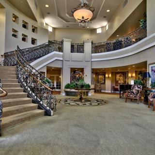 A grand lobby with a sweeping staircase and elegant chandelier.