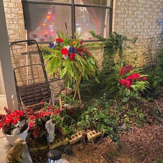 A vibrant display of flowers and greenery arranged outside a window, adding color to the garden space.