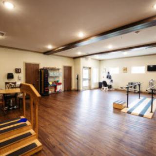 A spacious, well-lit interior with wooden flooring and neatly arranged furniture.