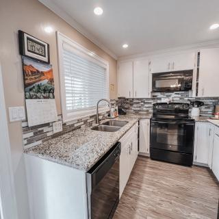 A modern kitchen featuring granite countertops and sleek black appliances.