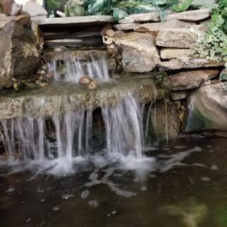 A serene waterfall cascading over natural stones, creating a peaceful atmosphere.