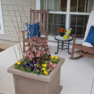 A cozy porch with rocking chairs and a decorative planter filled with colorful flowers.