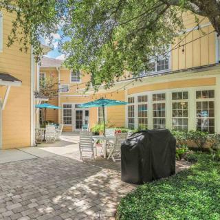 A cozy outdoor patio area with tables, chairs, and umbrellas next to a building.