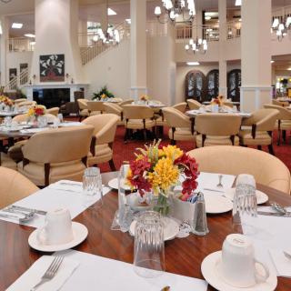 Elegantly set dining area with tables and flower arrangements.