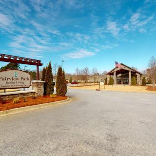 Entrance to a park with signage and a clear blue sky.
