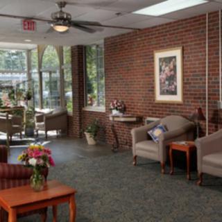 A cozy lobby area with comfortable seating, a brick wall, and natural lighting.