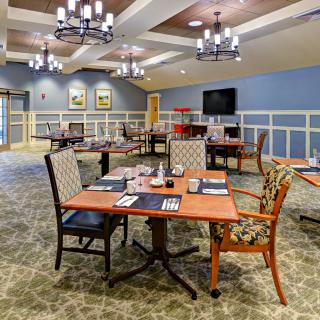 A well-lit and elegantly decorated dining area with neatly arranged tables and chairs.