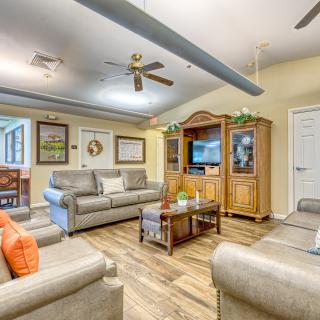 A cozy living room with sofas, a coffee table, and a television in an entertainment cabinet.