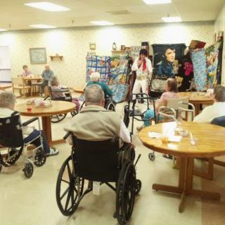 Elderly residents in a nursing home engage in communal activities.