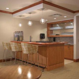 A modern kitchen bar area with a wooden countertop and seating.