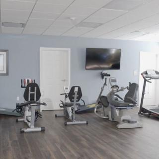 A fitness room equipped with exercise machines including treadmills and stationary bikes.