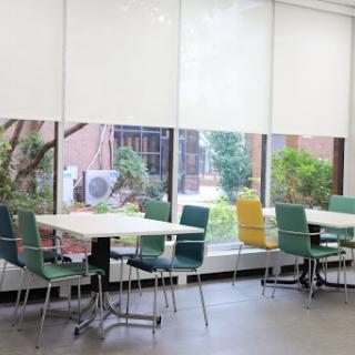 A bright and spacious break room featuring modern furniture and a view of greenery outside.