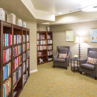 A cozy reading area with bookshelves and armchairs.
