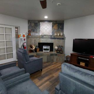 A cozy living room featuring comfortable seating, a modern fireplace, and a television, creating an inviting atmosphere.