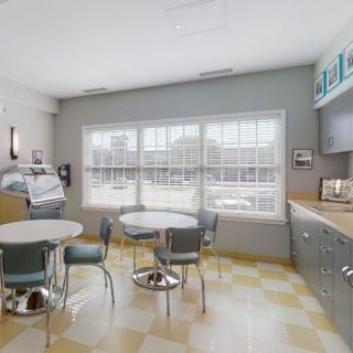 A modern kitchen with dining area, featuring ample natural light and contemporary furnishings.