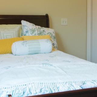 A neatly made bed with colorful pillows in a cozy bedroom.