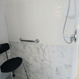 Accessible shower with grab bar and shower chair.