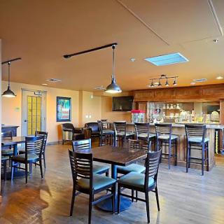 A spacious and inviting dining area featuring wooden furniture and a bar, perfect for gatherings.