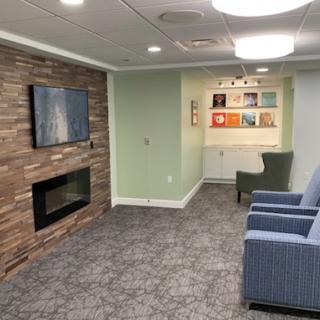 A cozy living room featuring a modern fireplace, a television, and comfortable seating.