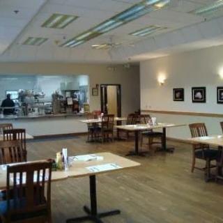 An empty restaurant dining area with neatly arranged tables and chairs.