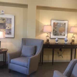 A cozy living space featuring a comfortable armchair, soft lighting, and tasteful artwork.
