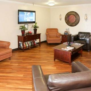 A cozy living room with leather sofas and a wall-mounted television.