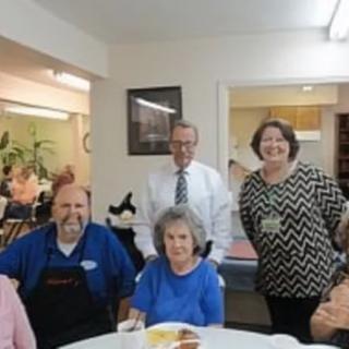 A group of people gathered around a table in a dining room setting.