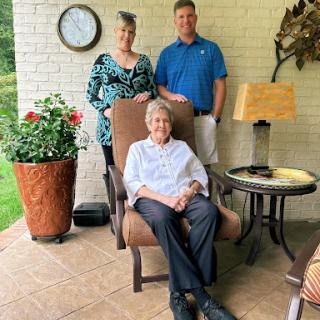 A family gathering on a patio, enjoying each other's company.