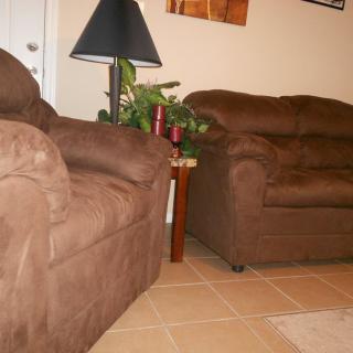 A cozy living room setup with two brown sofas and a floor lamp.