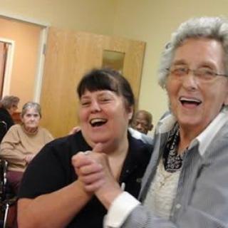 Two people joyfully dancing together in a community setting.