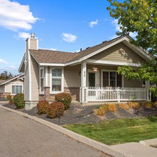 A charming suburban house with a front porch and landscaped yard.
