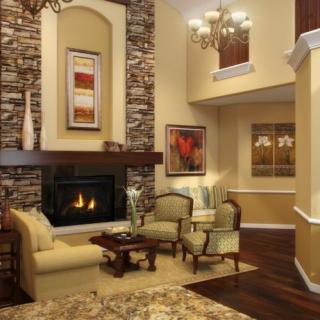 A cozy living room with a stone fireplace and elegant furnishings.