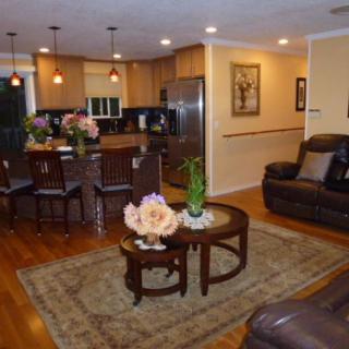A cozy open-plan living and kitchen area with modern furnishings and warm lighting.