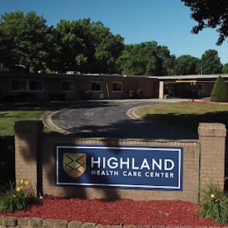 Entrance to the Highland Health Care Center, showcasing the facility's outdoor signage and landscaping.