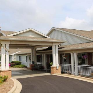 A building with a covered entrance and a driveway.