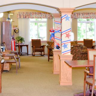 A cozy interior space with tables and chairs, decorated with red, white, and blue stars.