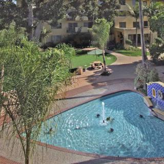 A view of a swimming pool with people enjoying a sunny day at an apartment complex.