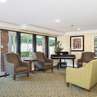 A cozy lobby seating area with armchairs and large windows.
