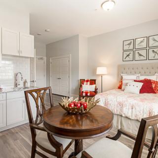 A cozy and modern bedroom with a small dining area, featuring elegant furniture and tasteful decor.