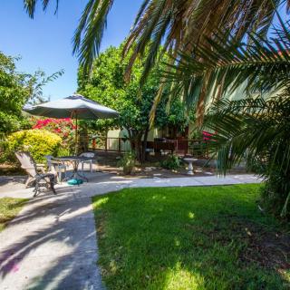 A tranquil garden setting with patio seating and umbrella.