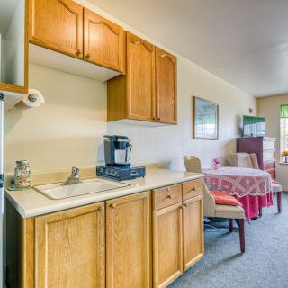A cozy kitchen and dining area with wooden cabinets and a coffee maker.