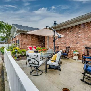 A cozy outdoor patio with furniture and an umbrella against a brick wall.