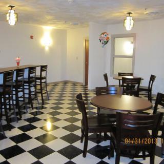 A checkered floor dining area with tables, chairs, and a bar section.